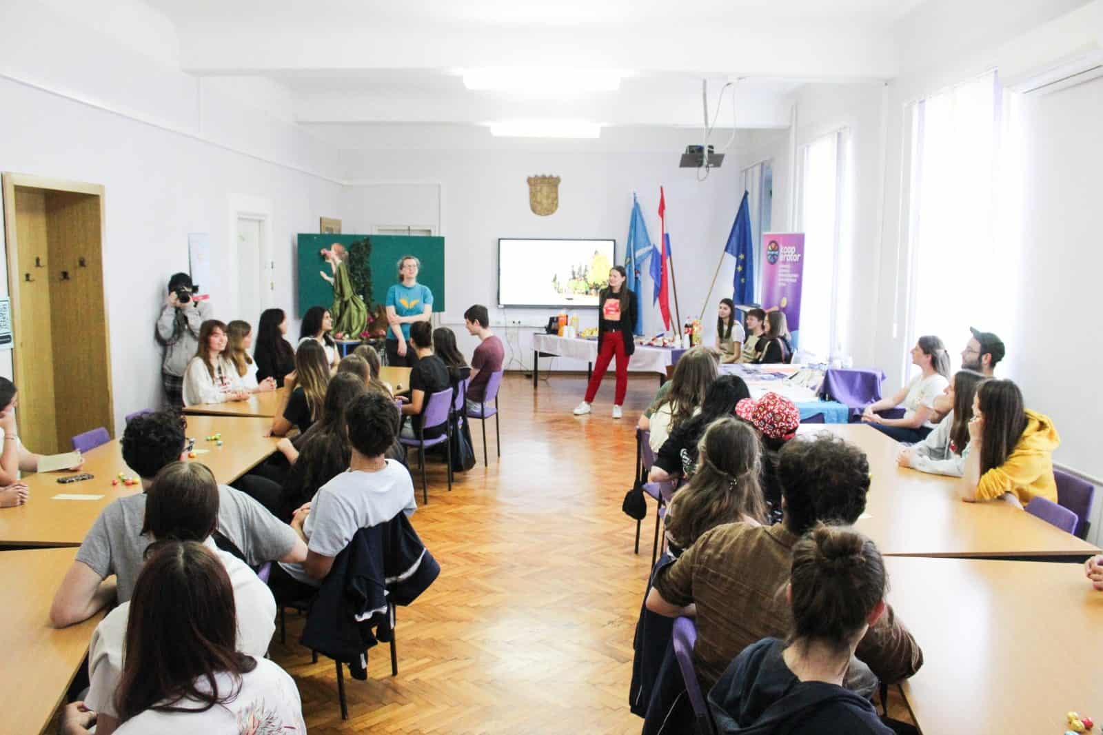 Maturanti iz švicarske Kantonsschule Zofingen pozorno slušajupredavanje u moderno opremljenoj učionici Prirodoslovne škole u Rijeci, Hrvatska, tijekom posjeta razmjene. Učenici su okruženi pločama s formulama i nastavnim pomagalima, odražavajući učenje i prijateljstvo.