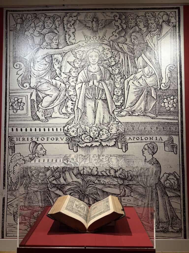 Djelo "Das Deutsch Römisch Brevier" (1518.) iz fonda NSK izloženo pred uvećanom preslikom ilustracije iz Brevijara na kojoj su prikazani Krsto i Apolonija Frankopan / Izvor: nsk.hr