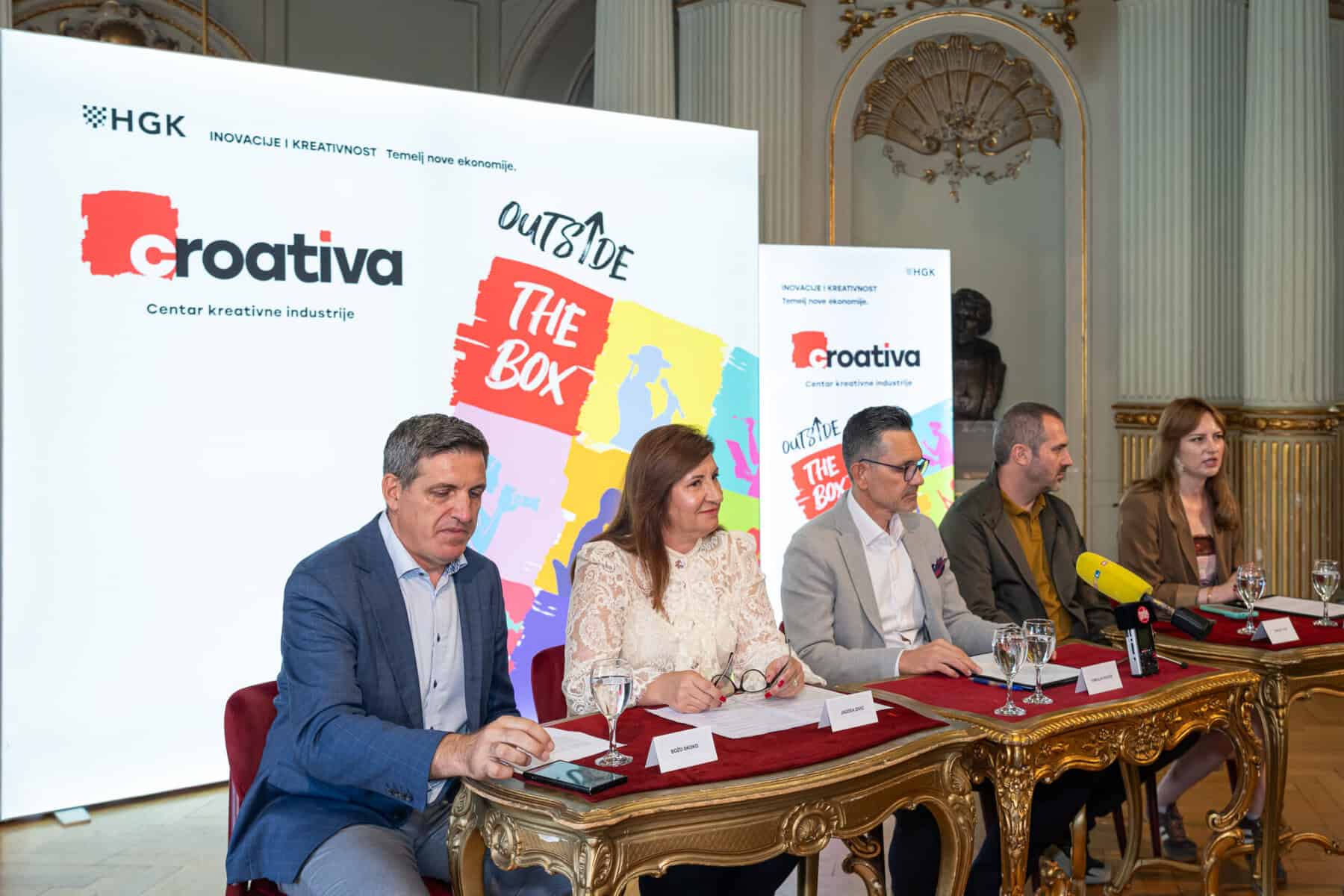 Sudionici predstavljanja inicijative CROATIVA HGK sjede za stolom s natpisima imena u HNK Zagreb, ispred zida s logotipom